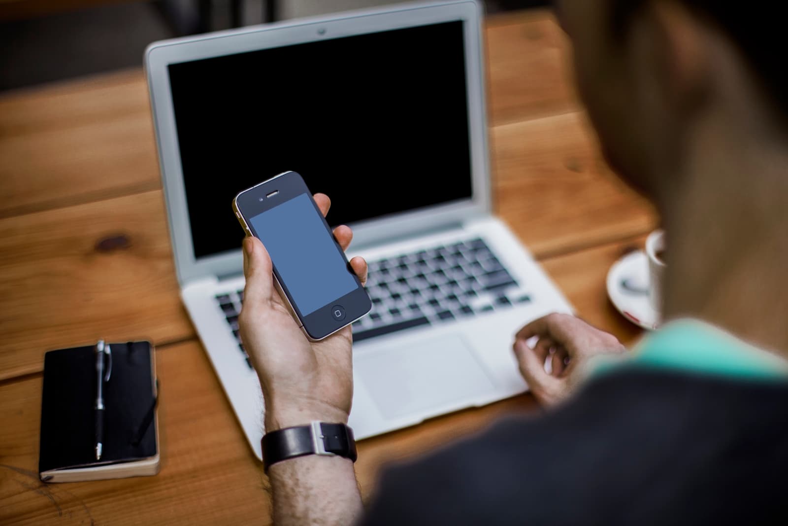 A shopper moving between a phone and a laptop mid-conversation