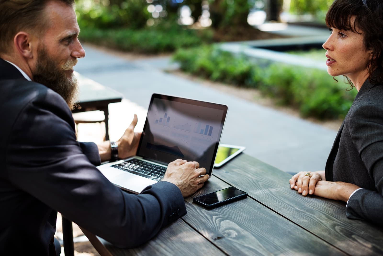 Two consultants reviewing customer experience performance data on a laptop